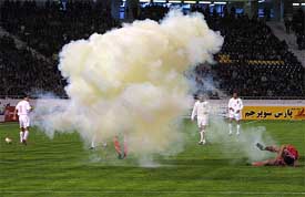 North Korea's So Hyok Chol lies on the ground after shrapnel from a fire cracker hit him on the face during their Asian Nations' Cup match against Iran 