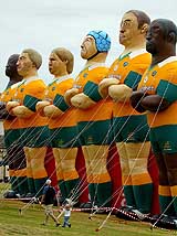 A girl and her father look up at huge inflatable figures of members of the Australian rugby team at Sydney's Bondi beach 