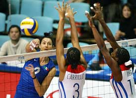 Italy's Rinieri Simona spikes the ball through Cuban blockers Carrillo de la Paz Nancy and Mesa Luaces Liana