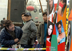 A man looks at a billboard promoting the 53rd Miss World contest in Xian, capital of China's central province of Shaanxi 