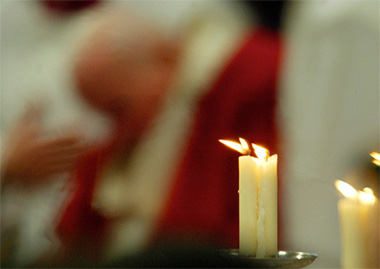 Candles burn as Pope John Paul II leads a mass inside Saint Peter's Basilica at the Vatican 