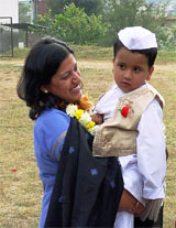 Mrs. Pallvi Gupta, Chairman of Hamirpur Red Cross Society, carries a child at the Bal Divas function