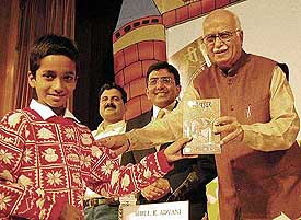 Deputy Prime Minister L. K. Advani presents a copy of the Hindi edition of �'Harry Potter' to 11-year-old Akhilesh Pandey, who reviewed the complimentary copy of the book and gave his comments, at the release of the book in New Delhi