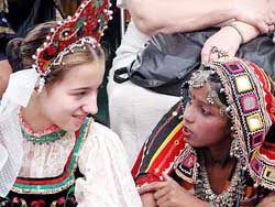 A girl dressed in traditional Rajasthani costume interacts with a Russian girl at the inauguration function of the International Children's Assembly and Integration Camp 2003 in New Delhi 