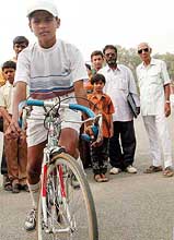Fourteen-year-old Dina Nath Katare, who cycled all the way from Pune to New Delhi on the eve of Children's Day, pose for photographers in front of Rashtrapati Bhavan 