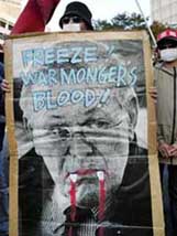 A Japanese student holds up a poster in protest against US Defence Secretary Donald Rumsfeld�s visit to Japan, near the US embassy in Tokyo on Friday.