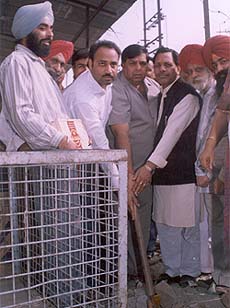 Mr Surinder Dawar, MLA, flanked by Mr Prem Mittal and area councillor Sanjeev Talwar commences the work for laying slabs on a small open drain