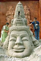 Indian artists give finishing touches to a sand sculpture of Chanakya