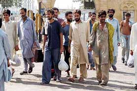 Pakistanis leave a port upon arrival in Karachi, Pakistan, on Friday after being deported from Oman