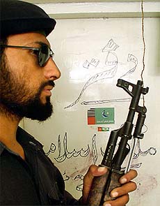 A Pakistani policeman stands guard near the offices of a banned Islamic militant group in Karachi
