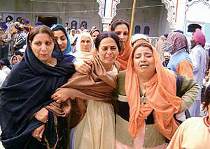 The wife (centre) and sister (right) of Surjeet Bindrakhia are consoled by relatives at his cremation in Ropar on Monday. 