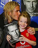English soccer captain David Beckham kisses a young fan at the launch of his book My Side in Manchester