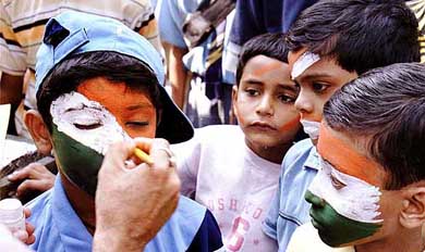 Children paint their face with the Tri-colour ahead of Tuesday's final between India and Australia at Eden Gardens in Kolkata 