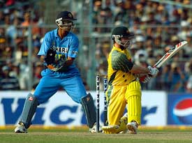 Australian batsman Damien Martyn hits a four wicketkeeper Rahul Dravid looks on