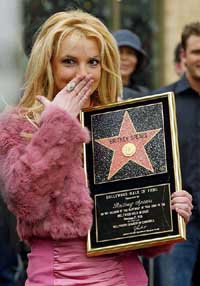 Pop star Britney Spears reacts as she holds up the plaque commemorating her as the new star on the Hollywood Walk of Fame in Los Angeles