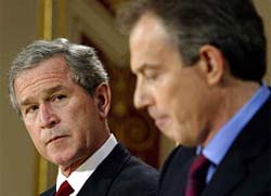 US President George W. Bush watches British Prime Minister Tony Blair pause during a joint Press conference in London