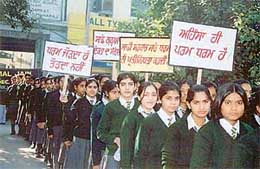 Schoolchildren hold a rally to promote communal harmony