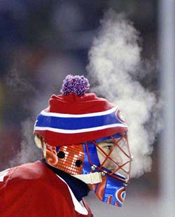 Montreal Canadiens goalkeeper Jose Theodore exhales during a second period of NHL outdoor action against the Edmonton Oilers at Commonwealth Stadium in Edmonton 