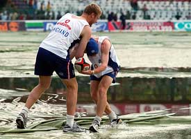 England's Andrew Flintoff and Paul Collingwood playfully tussle over a ball on plastic sheets at Premadasa Stadium in Colombo 
