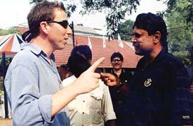 Former England cricketer Mike Atherton shares a light moment with former India cricket captain Kapil Dev during the Heritage Golf tournament in Kolkata 