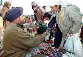 Kashmiri women buy bangles from a road-side shop on the eve of Id in Srinagar 