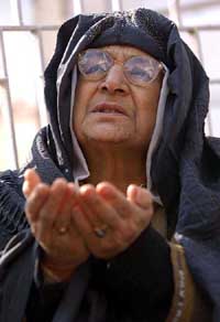An elderly veiled women prays for the return of peace to Jammu and Kashmir on the occasion of Id at Hazratbal Shrine in the out skirts of Srinagar 