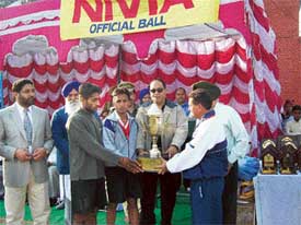 Mr Shiv Kumar, SSP gives away the trophy to players of Panjab University, winners of the 4th DN Mittal Memorial Football League played at Bassi Pathana