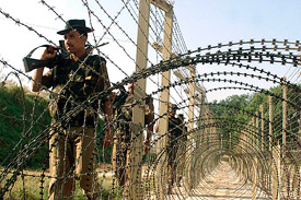 An Indian soldier patrols at the border with Pakistan near Chinaz village in Jammu and Kashmir on Thursday.