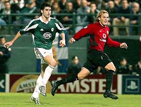 Manchester United's Diego Forlan turns to celebrate his goal while Panathinaikos FC's Silvio Maric watches in dismay