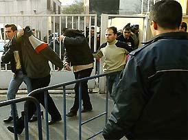 Two of the nine suspects, linked to the suicide bombings in Istanbul last week, cover their faces as policemen in Istanbul bring them to the State Security Court on Thursday