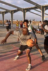 Soldiers of the US Army's 4th Infantry Division play basketball with Iraqi youths at a military camp outside Baquba, near Baghdad, on Friday