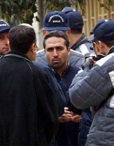 An unidentified suspect connected with the suicide bomb attacks on synagogues is surrounded by Turkish policemen and prosecutors during a re-enactment
