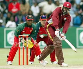West Indies batsman Chris Gayle attempts a leg-glance as Zimbabwean wicketkeeper Tatenda Taibu and slip fielder Craig Wishart look on