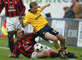 A.C. Milan's Massimo Ambrosini (L) tackles Nicola Campedelli of Modena during their Serie A clash at the San Siro stadium in Milan on Sunday