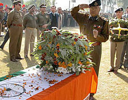 A police officer salutes a casket containing the body of constable Bal Krishan, who was killed in an encounter with Pakistani militants on the outskirts of Jammu