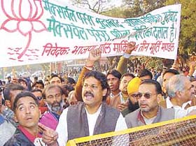 Kirti Azad, husband of Poonam Azad, candidate from Gole Market area, protesting outside the police headquarters in the Capital