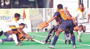 The Indian Oil custodian baulks the Indian Airlines forward in the final of the Shastri Hockey Tournament