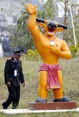 A security guard walks past the Southeast Asia (SEA) Games mascot in Hanoi