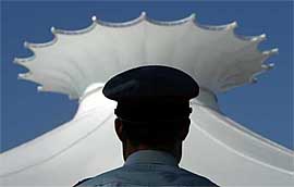 A policeman stands guard outside the Beauty Crown, the venue for the Miss World Final in Sanya