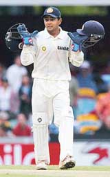 Wicketkeeper Parthiv Patel carries two helmets after poor light caused an early end to the first day's play of the first Test at the Gabba on Thursday