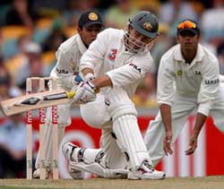 Australian batsman Justin Langer sweeps Harbhajan Singh on the first day of the first Test match in Brisbane on Thursday