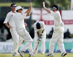 England players Ashley Giles, Marcus Trescothick and Paul Collingwood celebrate the dismissal of Sri Lankanbatsman Kumar Sangakkara on the third day's play of the first Test match in Galle