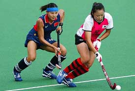 South Korea's Kwang Min Ko is attacked from behind by China's Mai Shaoyan during their Women's Champions Trophy hockey match in Sydney 