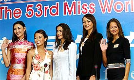 Miss China Qi Guan, Miss Hong Kong Yeung Lok-ting, Miss Canada Nazanin Afshin-Jam, Miss Poland Karolina Gorazda and Miss England Jacqueline Turner strike a pose at a news conference in Sanya
