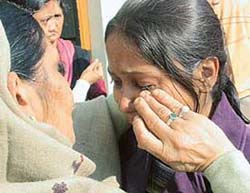 A neighbour consoles a daughter of Mrs Raj Rani whose house, at Preet Nagar Colony in Zirakpur, was burgled on 