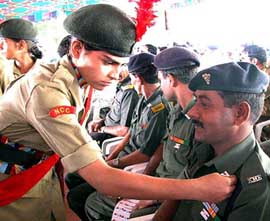 A cadet of NCC pins a flag on the collar of an Army jawan on the eve of Flag Day in Bhopal on Sunday