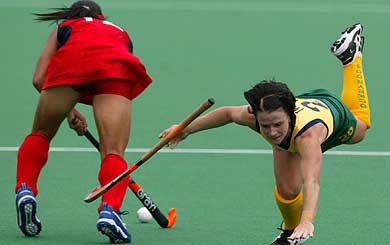 Australia's Carmel Bakurski falls over after being tackled by China's Zhou Wanfeng during the final of the Women's Champions Trophy hockey tournament in Sydney 
