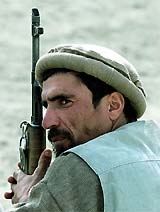 An Afghan man holds his gun during a disarmament programme, in which around 200 Afghan militiamen surrendered their arms
