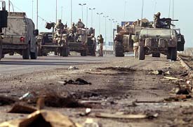 US troops block a highway on the outskirts of Baghdad after a roadside bomb attack on Sunday