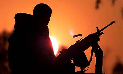 A machine gunner of US Army's 4th Infantry Division is silhouetted against the sunset